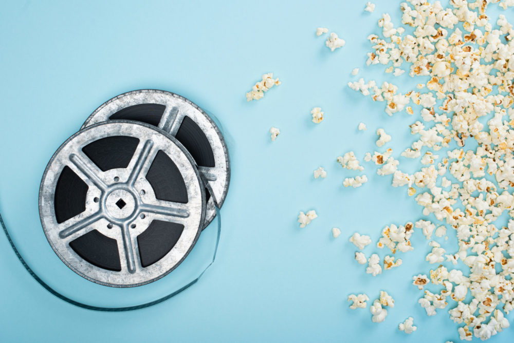 Film reels laying next to spilled popcorn