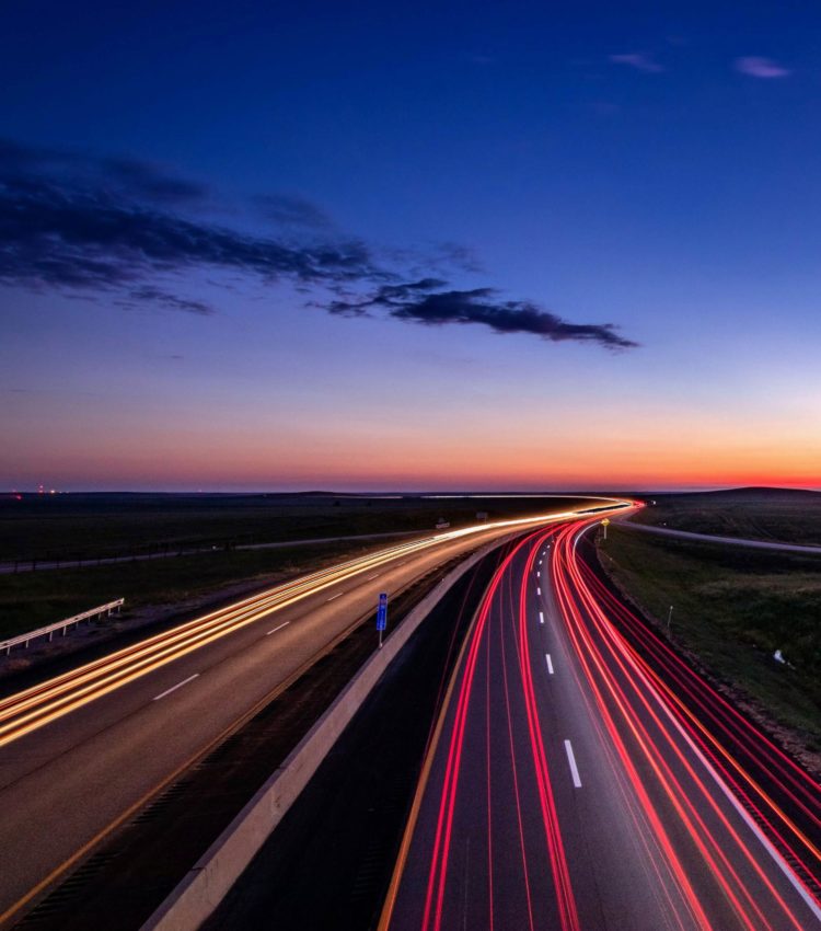 Roads merging on a highway at sunset