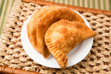 Cheese empanada, meat empanada or chicken empanada, on a white plate.